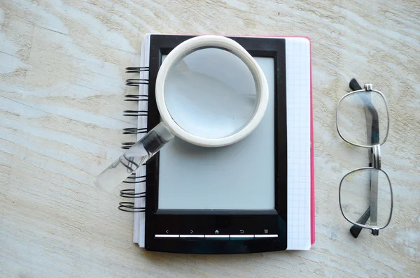 Libro elettronico nero con lente d'ingrandimento e occhiali — Foto Stock
