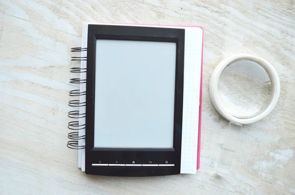 Black e-book and magnifying glass