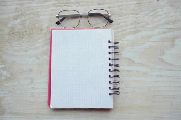Notebook with glasses on wooden table — Stock Photo, Image