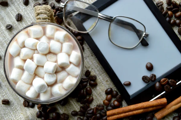 มาร์ชเมลโลว์ในถ้วยที่มีหนังสืออิเล็กทรอนิกส์และแก้วขนมและเมล็ดกาแฟ — ภาพถ่ายสต็อก