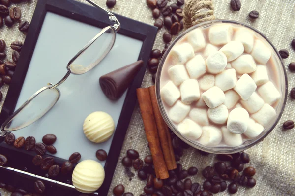 Marshmallows in Schüssel mit Ebook und Gläsern, Bonbons und Kaffeebohnen — Stockfoto
