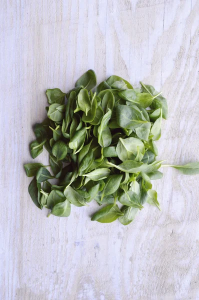Spinach on wooden table — Stock Photo, Image