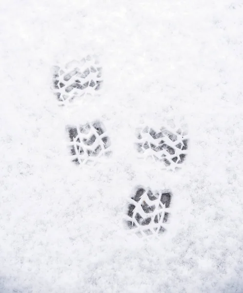 Two boot prints in the snow in winter