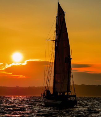 Günbatımı harika olan bir yelkenli.