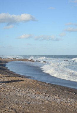 Yazın sörf yapılan güzel bir sahil ve deniz manzarası.