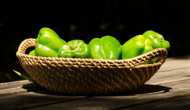 bir hasır ve ahşap sepet üzerinde yeşil biber veya dolmalık biber perspektif