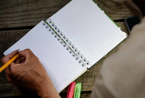 Gaucher Écrivant Crayon Dans Cahier Sur Bois Avec Téléphone Portable — Photo