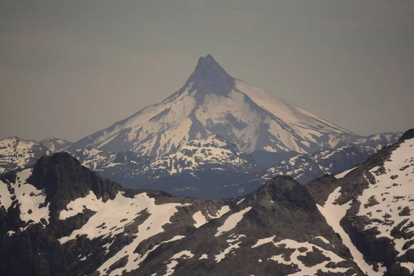 Arkasında Heybetli Bir Volkan Olan Karlı Dağlar Manzarası — Stok fotoğraf