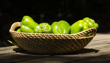 bir hasır ve ahşap sepet üzerinde yeşil biber veya dolmalık biber perspektif