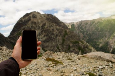 cell phone on top of the mountain, looking for signal, hand taking it to connect