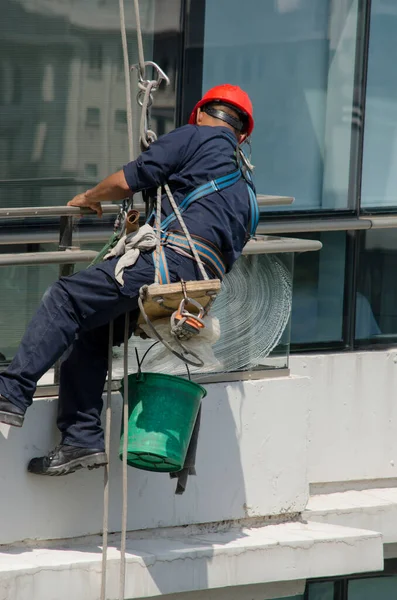 工人们用工作服在建筑物高的地方擦玻璃 冒着生命危险工作 — 图库照片