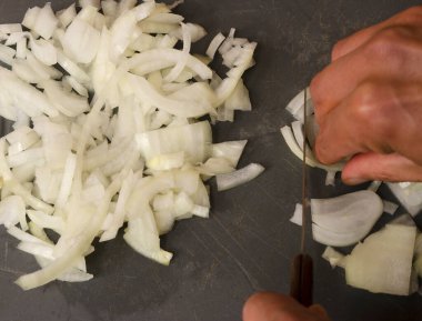 Plastik tahtada beyaz soğan kesmek, yemek hazırlamak.