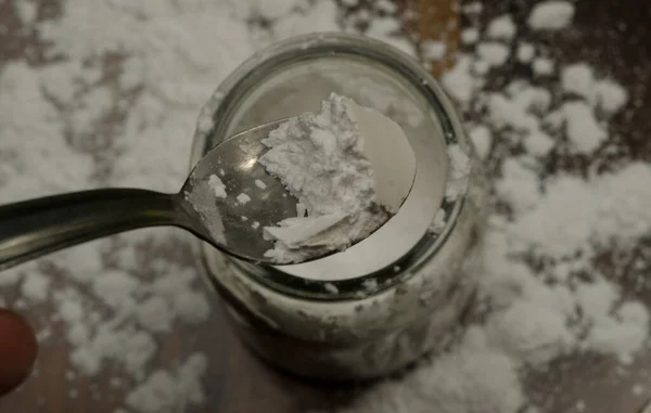 baking powder in spoon on wood. Taken out of a jar, or it can be baking soda