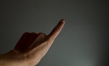 Bir numarayı parmaklarıyla, birliğin sinyalini eliyle gösterir.