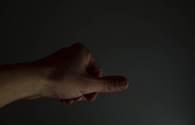 El başparmakla ne aşağı ne yukarı, ne de el, ne evet ne de hayır işareti olarak.