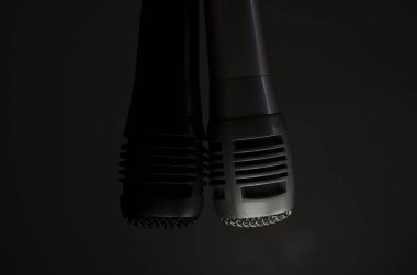 iki mikrofon, bir siyah ve bir gri arka planda asılı, kayıt, şarkı söyleme, iletişim konsepti