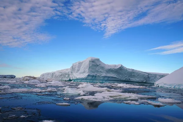 氷が溶けて海に浮いたものもある 青い空と放射状の雲は南極の夏の風景です — ストック写真