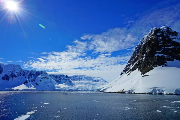太阳挂在天空中 冰山上融化的雪揭示了岩石 现在是南极的夏天 — 图库照片