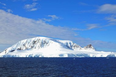 Çeşitli buz dağları manzaraları. Buz kütleleri, buzullar, okyanuslar, radyoaktif bulutlar, güneş ışığı var. Bu Antarktika yazı..