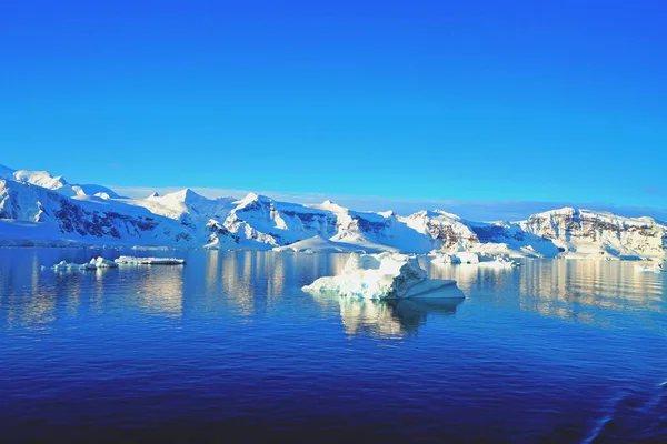 Çeşitli buz dağları manzaraları. Buz kütleleri, buzullar, okyanuslar, radyoaktif bulutlar, güneş ışığı var. Bu Antarktika yazı..