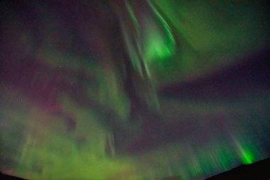 Gece gökyüzünde Aurora Borealis. Açık renkler yeşil, sarı ve kırmızıdır. Fotoğraf: Alaska, ABD 17 Mart 2016