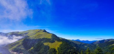 Dağların güzel manzarası, mavi gökyüzü, beyaz bulutlar ve temiz hava. Tayvan 'daki Central Cross Island Otoyolu' nun manzarası. Aralık 2020.