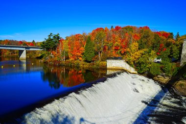 Sonbaharda renkli ağaçlar ve mavi gökyüzü ile Şelale ve Köprü. Montmorency Falls Park (Parc de la Chute-Montmorency), Quebec, Kanada, 2016.