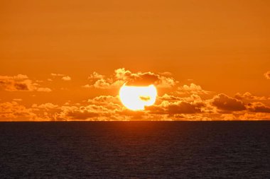Güneş ışığı zaman zaman bulutlar arasında belirdi ve kayboldu. Sis çok göz kamaştırıcı. Tekneden görünen gün batımı. Kuzey Pasifik Okyanusu, Haziran 2019.
