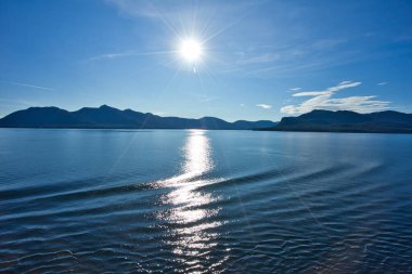 Güneş ışığı adanın önündeki göl üzerinde haritalanmıştır. İdealist bir manzara. Ketchikan, Alaska gerçekten 