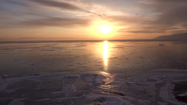夕暮れ時の凍ったベルグレ湖の景色 カメラは横に撃たれた バイカル湖 様々な雪と氷の風景です ロシアのイルクーツク州 2019年1月 — ストック動画