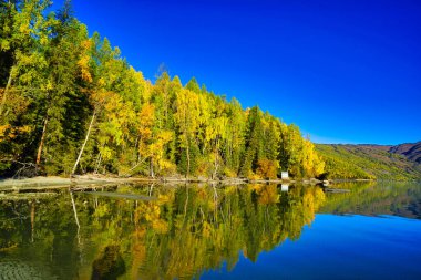 Gölün ve dağların sessizliği. Mavi gökyüzünün yansıması. Kanas Gölü, doğal bir göl ve dağ cenneti. Xinjiang Eyaleti, Çin. Eylül 2018