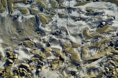 Flowing pattern. River water passes through the stone to form a silky pattern. Kanas Lake, a natural lake and mountain paradise. Xinjiang Province, China. Sep. 2018 clipart