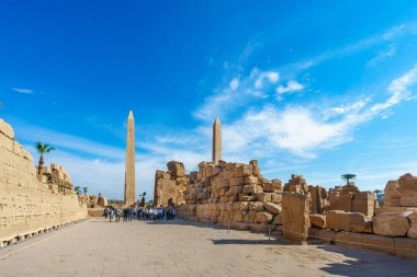 Luxor, Mısır - 18 Ocak 2025: Turistler, Karnak Tapınağı 'nın antik harabelerinde, parlak bir bahar sabahı ayakta duran dikili taş duvarlar ve yazılı taş duvarlar arasında yürürler..