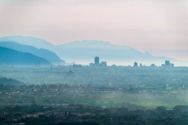 Yuanshan Kasabası, Tayvan 'da yaz şafağı sisli katmanlı dağlarla Yilan Ovası' ndaki uzak şehir siluetini rüya gibi gökyüzü altında çerçeveliyor..