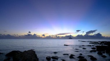 Wanli New Taipei 'de şafak öncesi turuncu mavi gökyüzünü gösteriyor ufuktan gelen pembe ışınlar ve denizin üzerinde sürüklenen kara bulutlar.