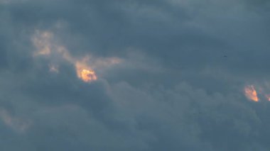 Hızlı hareket eden gri ve koyu yağmur bulutlarının dramatik yakın çekimi. Güneş aralıklı olarak boşluklardan görünüyor. Atmosfer, Dawulun Balıkçılık Limanı Keelung Tayvan yakınlarında kasvetli.