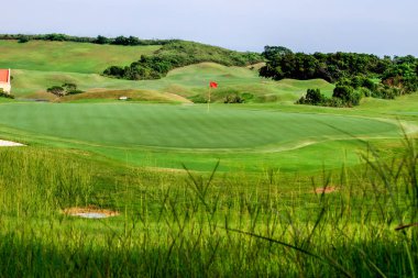 Lukou, Taoyuan City 'deki golf sahasındaki yemyeşil otlakların panoramik manzarası. Yuvarlanan tepeler ve sık ormanlarla çevrili. Açık hava için ideal..