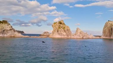 Miyako City Iwate 'deki Jodogahama Sahili' nde mavi gökyüzünün altında saf doğal güzelliğiyle ünlü küçük bir tekneyle turkuaz denizinden yükselen beyaz kaya oluşumlarının nefes kesici görüntüsü..