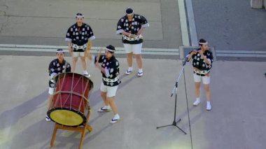 Akita City, Japonya - 25 Ekim 2025 Performansçılar iskelede Kanto fenerleri taşıyorlar. Müzisyenler sonbahar günbatımında bir yolcu gemisine veda etmek için davul ve flüt çalarlar..