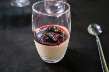 Koyu böğürtlen kompostosu ile kaplanmış kremalı panna cotta içeren zarif katmanlı tatlı İspanya 'daki Don Kişot Yolu boyunca işlenmiş mutfağı temsil ediyor..