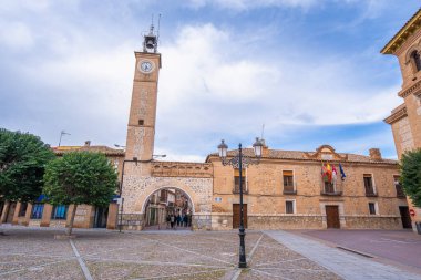 İspanya 'nın Don Kişot Yolu boyunca uzanan tarihi bir kasaba olan Consuegra' da tuğla saat kulesi ve belediye binalarının yer aldığı geleneksel İspanyol meydanı..