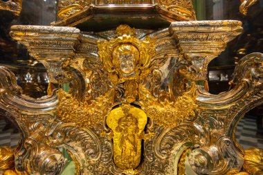 Cordoba, İspanya - 13 Mart 2025: Karmaşık rokoko kaydırma ve gümüş kabartmalı temel panel içeren ayrıntılı altın barok sunak detayı.