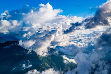 Hehuanshan 'ın, Renai' nin, Nantou 'nun, Tayvan' ın hava manzarası. Sonbahar güneşi, bulutların ve yeşil yamaçların üzerinde dolambaçlı bir dağ yolunu aydınlatır..