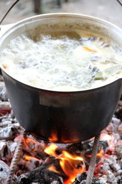Balık likörü. Sıcak ve lezzetli nehir alabalığı ve sebze bulyonu. Sağlıklı ve lezzetli bir turist yemeği. Yemek ateşte pişiyor..
