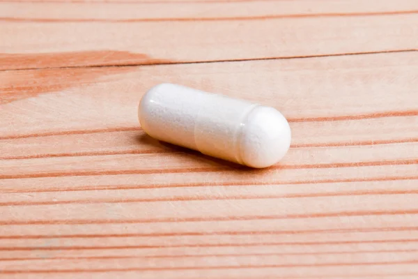 Píldoras blancas sobre madera — Foto de Stock