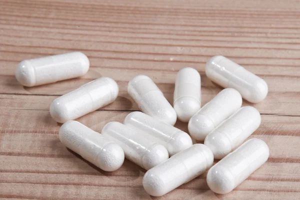 Píldoras blancas sobre madera —  Fotos de Stock