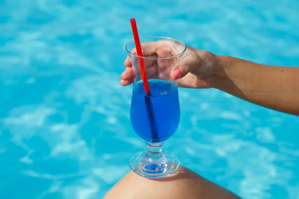 Blue cocktail near pool in the hand — Stock Photo, Image