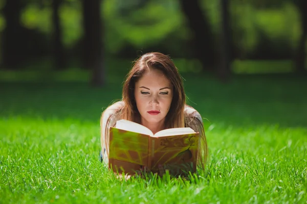 Mädchen mit Buch auf dem Gras — Stockfoto