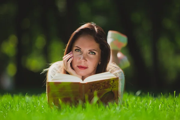 Mädchen mit Buch auf dem Gras — Stockfoto