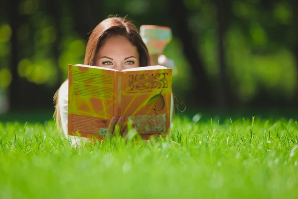 Mädchen mit Buch auf dem Gras — Stockfoto